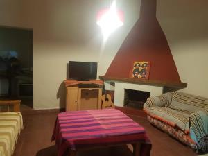 ein Wohnzimmer mit einem Kamin und einem TV in der Unterkunft Hamacas Serranas in Salsipuedes