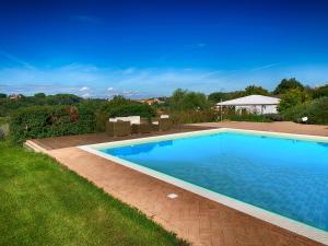 a large swimming pool in a yard with a grass field at Casale Cardini in Foiano della Chiana