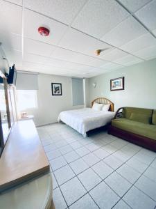 a bedroom with a bed and a couch at Parador El Buen Cafe in Hatillo