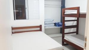 a bedroom with a bunk bed and a mirror at Villagio Aloha Beach in Bertioga +36 photos