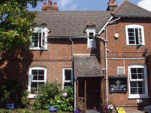 a red brick house with white windows and a door at Riverside House in Hamble