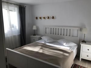 um quarto branco com uma cama e uma janela em Bb's Cosy Apartments em Braşov