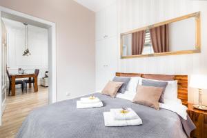 a bedroom with a large bed with towels on it at Comfort Studio Central in Szczecin