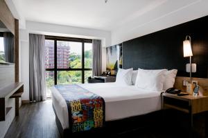
a hotel room with a large bed and a large window at Arena Ipanema Hotel in Rio de Janeiro
