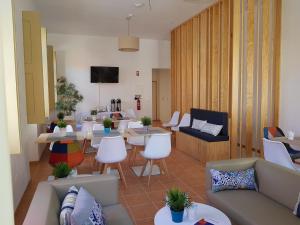 un soggiorno con divani, tavoli e sedie di Águeda Hostel & Friends ad Águeda