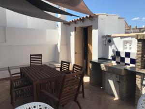 a patio with a table and chairs on a roof at The Blue House in Olhão