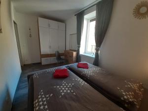 Un dormitorio con una cama con almohadas rojas. en Haus Renè, en Villach