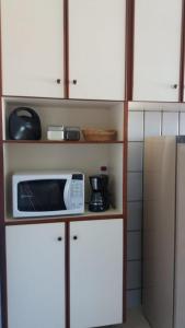 a microwave sitting on top of a kitchen cabinets at Apartamento Mundi - Império Romano - Caldas Novas in Caldas Novas