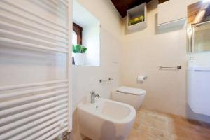 a white bathroom with a toilet and a sink at Authentic Villa Surrounded by Nature in Terni +31 photos