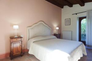 1 dormitorio con cama blanca y mesita de noche de madera en Authentic Villa Surrounded by Nature en Terni