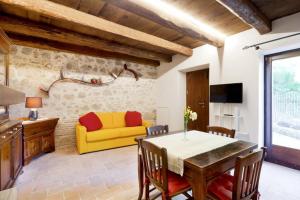 un soggiorno con divano giallo e tavolo di Authentic Villa Surrounded by Nature a Terni