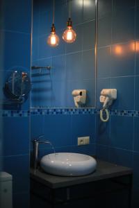 un bagno blu con un lavandino e uno specchio di OTAKHEBI a Sarpi