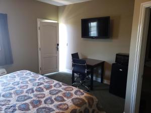 a hotel room with a bed and a desk and a television at Hotel Portlight in Wilmington +7 photos