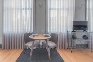 a dining room with a table with chairs and a tv at Citybreak-apartments Coliseu in Porto