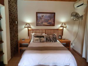a bedroom with a large bed with two night stands at A Traveller's Palm in Phalaborwa
