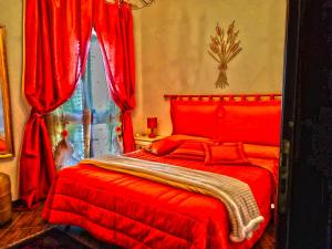 a red bed in a bedroom with red curtains at SEGESTA Nouveau Bedding in Salemi