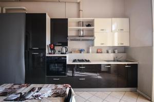 una cucina con armadietti bianchi e neri e un bancone di Stop & Sleep Bergamo a Bergamo