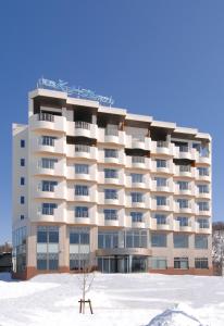 a large building with snow in front of it at Shiretoko Noble Hotel in Shari