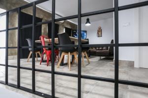 a dining room with a table and red chairs at Apartamentos Ohana Mérida - Centro - Parking Gratis - Todo a Pie - Pet Friendly - Espacios Exclusivos in Mérida