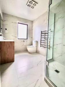 uma casa de banho com uma cabina de duche em vidro e um lavatório. em Flat Bush Private Ensuite em Auckland