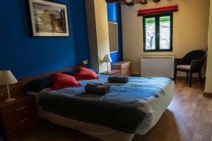 Schlafzimmer mit blauen Wänden und einem Bett mit roten Kissen in der Unterkunft Apartamento La Hoz in Cuenca