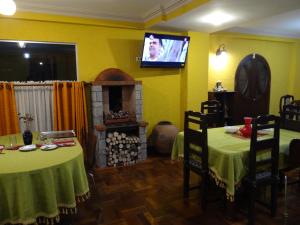 a room with two tables and a fireplace and a tv at Hostal Bivouac in La Paz