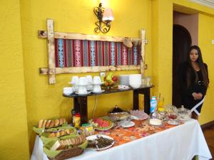 Eine Frau steht neben einem Tisch mit Essen. in der Unterkunft Hostal Bivouac in La Paz
