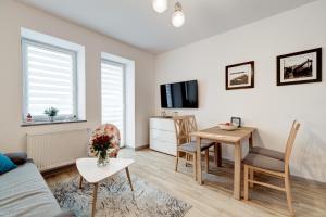 a living room with a table and a dining room at Apartament SŁONECZNY - Aprent in Dziwnówek