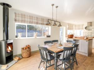 a kitchen and dining room with a table and a fireplace at Giggling Goose Cottage in Woodhall Spa