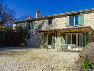 una vieja casa de piedra con una mesa delante en lou baïto, en Condorcet