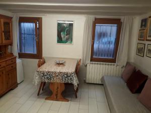 ein Esszimmer mit einem Tisch und einem Sofa in der Unterkunft Casa Lorella in Chioggia