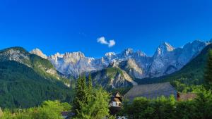 a mountain range with a house in front of it at Apartments in Villa Flora in Kranjska Gora