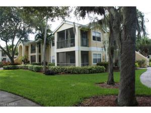 a large apartment building with a tree in the yard at Beautiful two master bedroom condo in Fort Myers, Venetian Palms condominium in Fort Myers