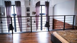 a bedroom with a bed and some windows at RedCity LOFT in Żyrardów