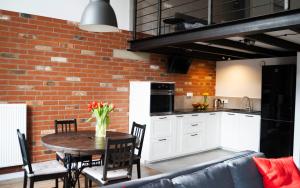 a kitchen and dining room with a table and a brick wall at RedCity LOFT in Żyrardów