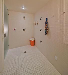 a bathroom with a tiled shower with an orange trash can at Island Inn at 123 West in Friday Harbor