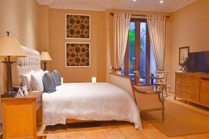 a bedroom with a bed and a dresser and a television at Bastión Luxury Hotel in Cartagena de Indias