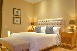 a bedroom with a large white bed and two lamps at Bastión Luxury Hotel in Cartagena de Indias