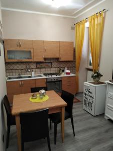 a kitchen with a wooden table and chairs and a kitchen with a stove at Casa Pif in Frosinone