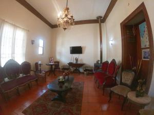 ein Wohnzimmer mit Stühlen, einem Tisch und einem Fernseher in der Unterkunft Hotel Escorial in La Serena