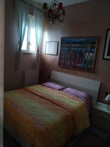 1 dormitorio con 1 cama y una pintura en la pared en Casa Pif, en Frosinone