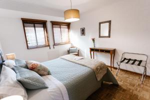 a bedroom with a bed and a desk and a table at Castle Apartment in Guimarães