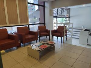 uma sala de espera com cadeiras e uma mesa de centro em Igaras Hotel em Otacílio Costa