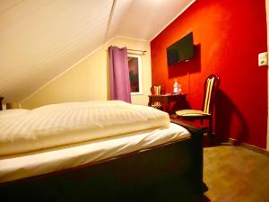 a bedroom with a bed with a red wall at Der Gutschmecker Bad Bramstedt in Bad Bramstedt