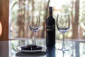 una botella de vino y dos copas de vino en una mesa en Rincon de Maria Mazamitla, en Mazamitla