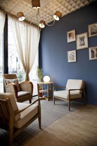 a living room with chairs and a blue wall at Hôtel d'Orsay in Toulouse