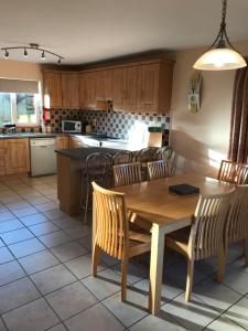 a kitchen with a wooden table and chairs and a counter at 1 Sheen View in Kenmare