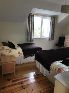 a bedroom with two beds and a window at 1 Sheen View in Kenmare