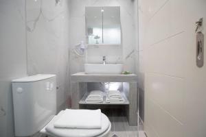 a white bathroom with a sink and a toilet at Elenas home in Vasiliki