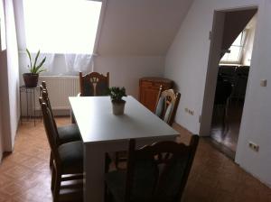 a dining room with a white table and chairs at Forsthof in Bergen